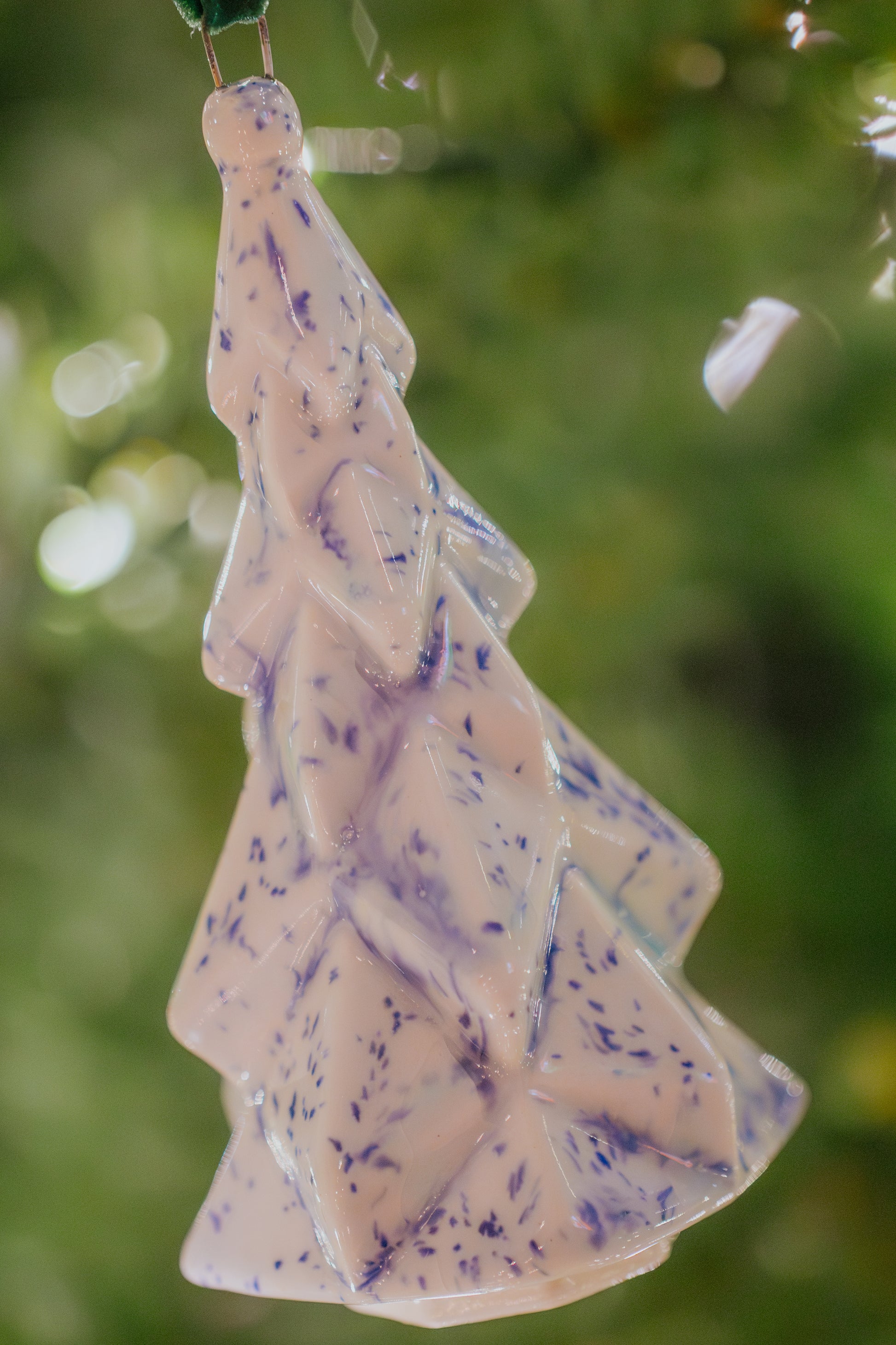 Faceted Ceramic Tree ornament with blue speckles hanging on a Christmas tree