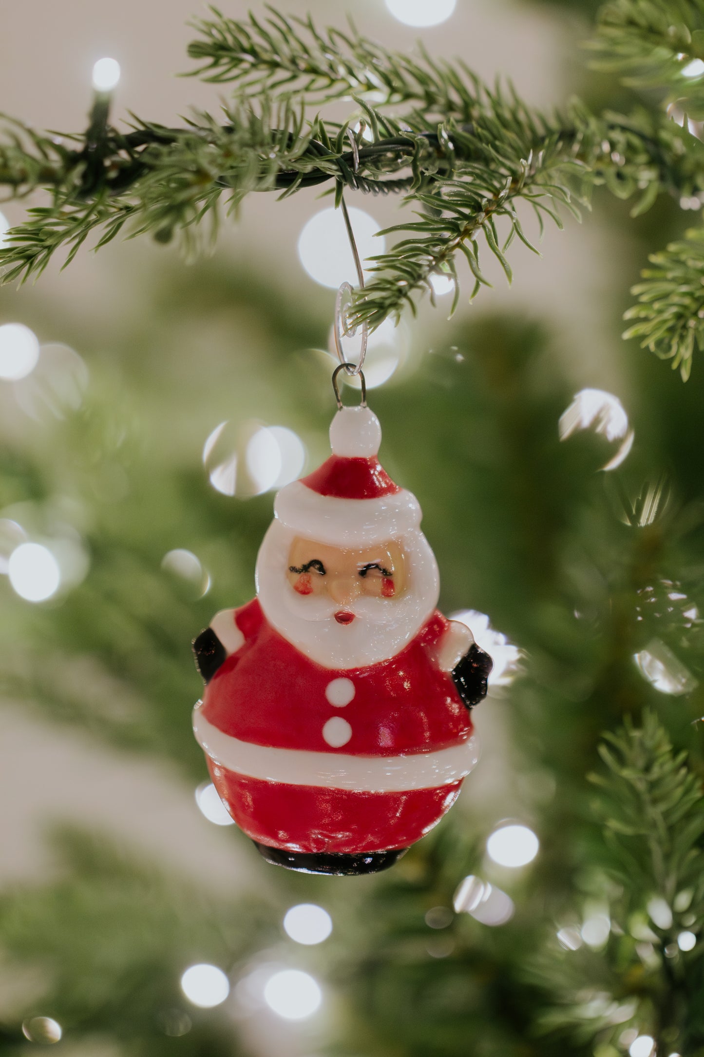Vintage ceramic chubby Santa ornament cast from a 1967 Duncan mold, hanging on a Christmas tree as heirloom holiday decor